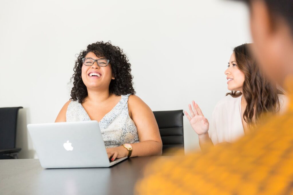 pexels-photo-1181743 Professional women engaged in a lively meeting at the office using technology.